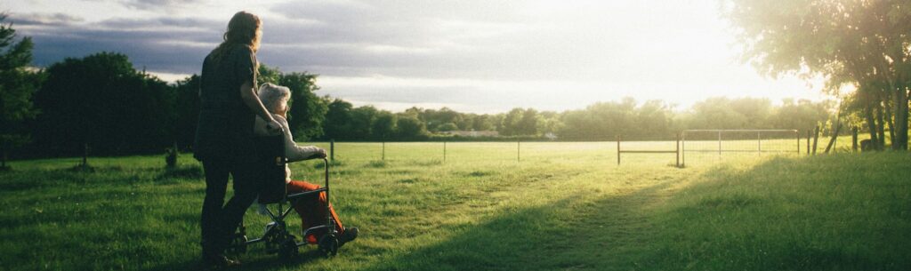 woman standing next to woman riding wheelchair