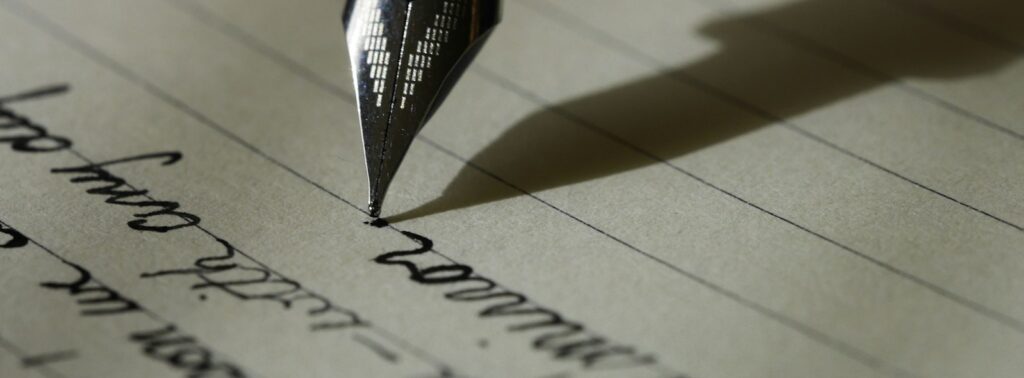 fountain pen on black lined paper